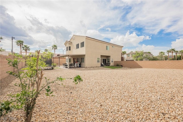 back of property featuring stucco siding, a patio, and a fenced backyard