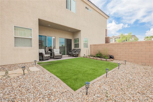 back of property featuring a fenced backyard, a lawn, a patio, stucco siding, and an outdoor living space
