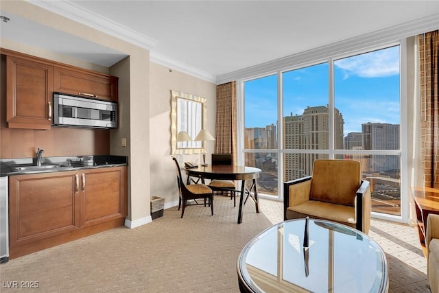 145 E Harmon Ave Unit 2411, Las Vegas, NV 89109 - kitchen featuring stainless steel microwave, brown cabinetry, ornamental molding, a sink, and baseboards