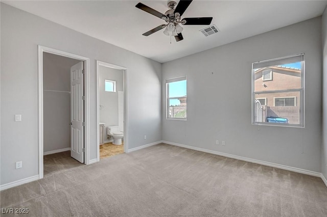 unfurnished bedroom featuring baseboards, visible vents, carpet, and a spacious closet