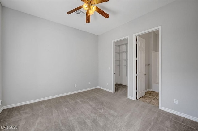 unfurnished bedroom with carpet floors, baseboards, a spacious closet, and visible vents