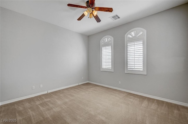 carpeted empty room featuring baseboards, ceiling fan, and visible vents