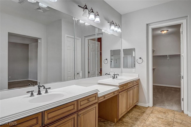 full bath featuring double vanity, baseboards, visible vents, and a sink