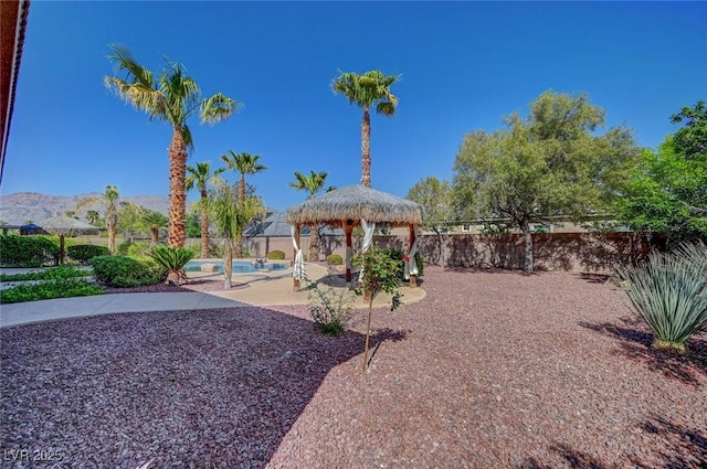 view of yard with a gazebo, a fenced backyard, a fenced in pool, and a patio