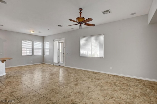 empty room with a ceiling fan, baseboards, and visible vents