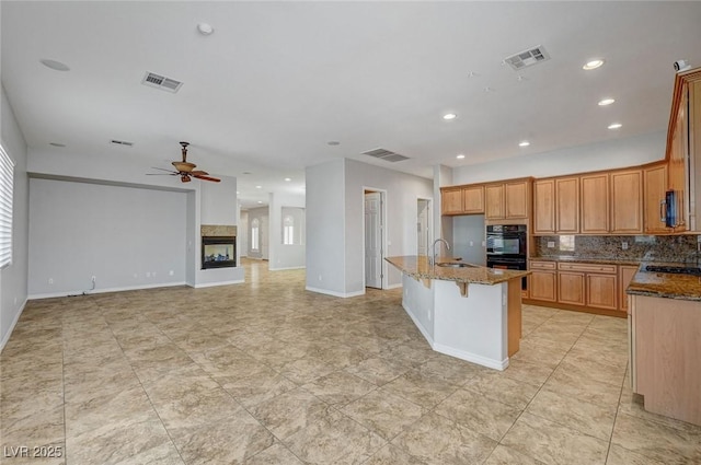 kitchen with visible vents, a sink, a ceiling fan, and dobule oven black