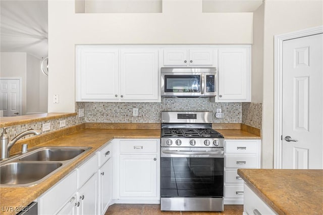 9539 Iris Flat Ct, Las Vegas, NV 89178 - kitchen featuring stainless steel appliances, a sink, backsplash, and white cabinetry