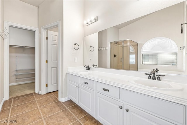 9539 Iris Flat Ct, Las Vegas, NV 89178 - bathroom with a stall shower, tile patterned flooring, double vanity, and baseboards