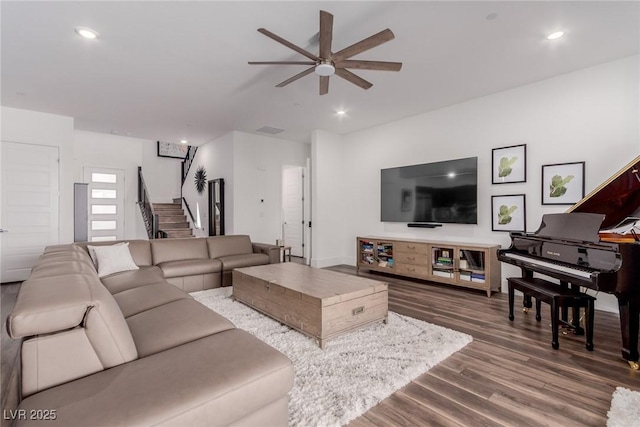 living area with ceiling fan, dark wood finished floors, stairs, and recessed lighting