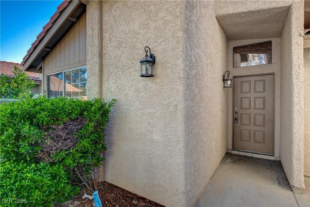 view of exterior entry featuring stucco siding