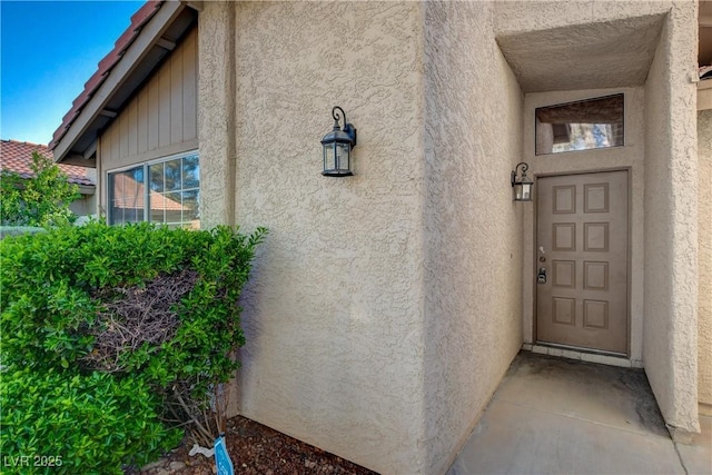 view of exterior entry featuring stucco siding