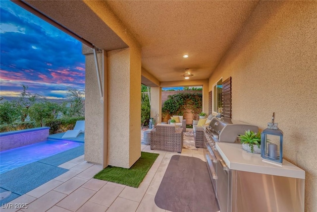patio terrace at dusk featuring an outdoor pool, grilling area, and an outdoor hangout area