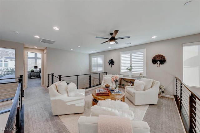 living room with light colored carpet, a ceiling fan, visible vents, and recessed lighting