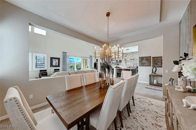 dining area featuring a chandelier and baseboards