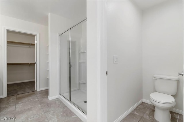 5317 Golden Melody Ln, North Las Vegas, NV 89081 - bathroom with a shower stall, a walk in closet, tile patterned floors, toilet, and baseboards