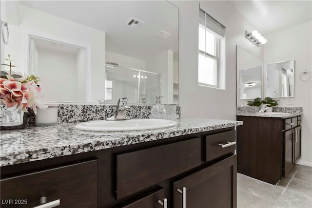 5317 Golden Melody Ln, North Las Vegas, NV 89081 - full bathroom featuring two vanities and a shower stall