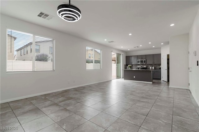 5317 Golden Melody Ln, North Las Vegas, NV 89081 - unfurnished living room with light tile patterned flooring, recessed lighting, and baseboards