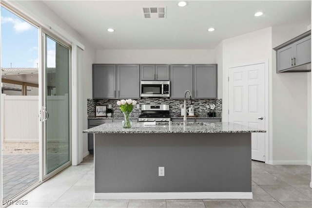 5317 Golden Melody Ln, North Las Vegas, NV 89081 - kitchen featuring appliances with stainless steel finishes, gray cabinets, light stone countertops, backsplash, and recessed lighting