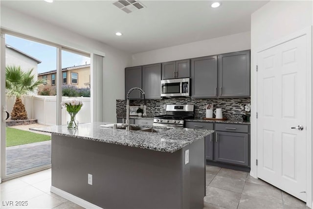 5317 Golden Melody Ln, North Las Vegas, NV 89081 - kitchen with appliances with stainless steel finishes, stone counters, gray cabinetry, backsplash, and recessed lighting