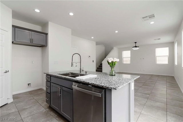 5317 Golden Melody Ln, North Las Vegas, NV 89081 - kitchen with stainless steel dishwasher, a sink, light stone countertops, a center island with sink, and light tile patterned floors