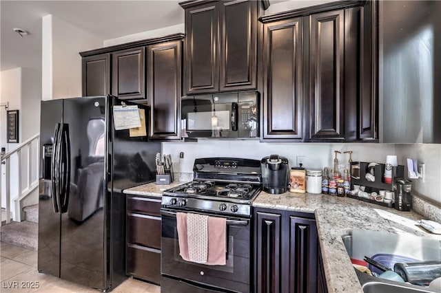 kitchen featuring black appliances, light tile patterned flooring, dark brown cabinetry, and light stone countertops