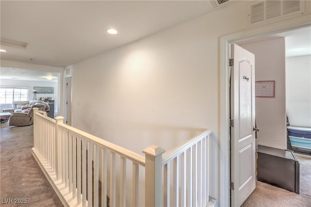 hallway featuring an upstairs landing, carpet flooring, visible vents, and recessed lighting