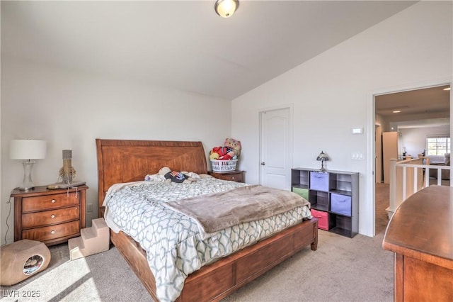 bedroom featuring light colored carpet and lofted ceiling