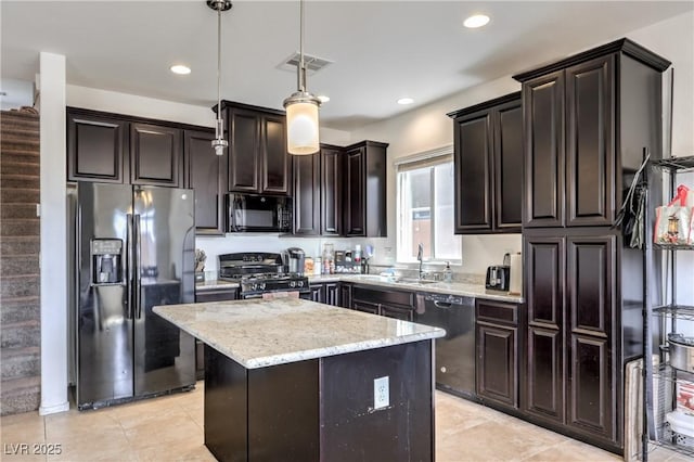 kitchen featuring visible vents, black appliances, light stone counters, a sink, and decorative light fixtures