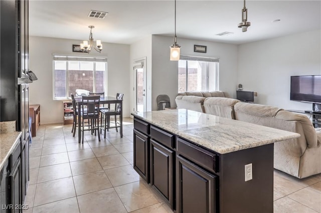 kitchen featuring pendant lighting, visible vents, light tile patterned flooring, open floor plan, and a notable chandelier