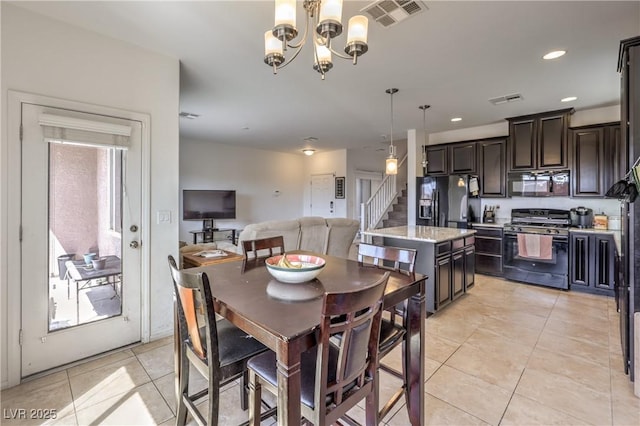 dining area featuring an inviting chandelier, light tile patterned floors, visible vents, and stairway