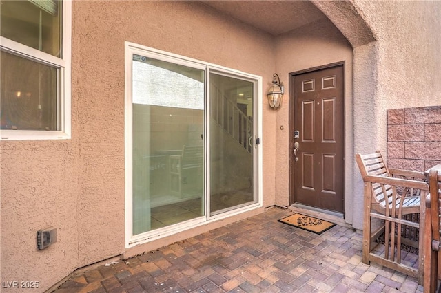 view of exterior entry with stucco siding