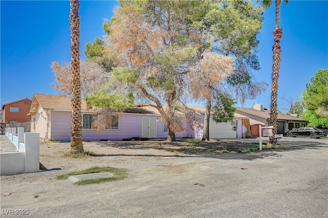 view of front of home with fence and a garage