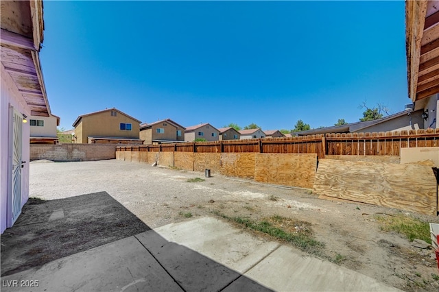 view of yard with a fenced backyard, a patio, and a residential view