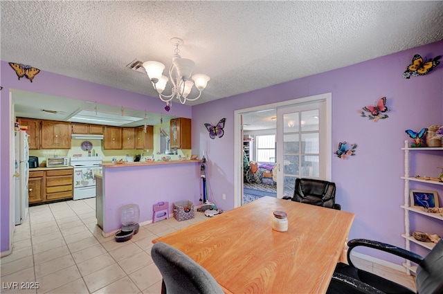dining space featuring light tile patterned flooring, a notable chandelier, and a textured ceiling