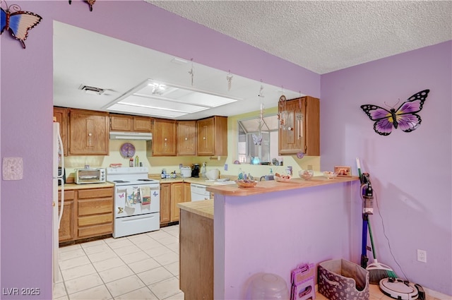 kitchen featuring light tile patterned floors, white appliances, a peninsula, light countertops, and a toaster