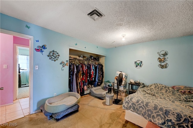 bedroom with visible vents, a closet, and a textured ceiling