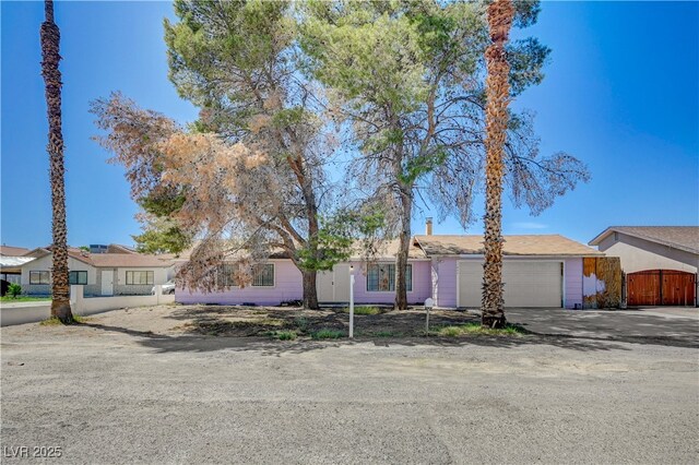 view of front of home with fence, a gate, a garage, and concrete driveway
