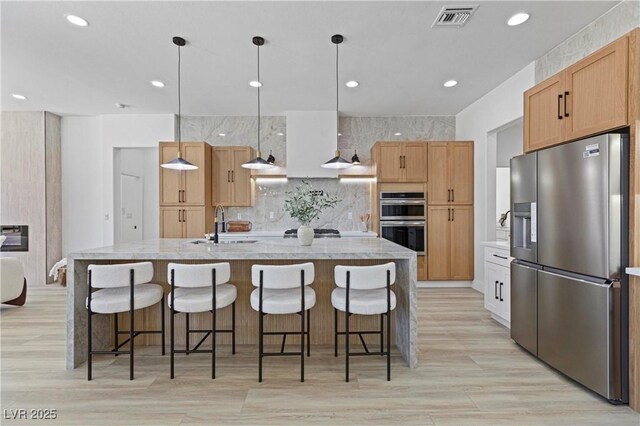 2317 Sierra Heights Dr, Las Vegas, NV 89134 - kitchen featuring stainless steel appliances, decorative backsplash, recessed lighting, a large island, and light wood-type flooring