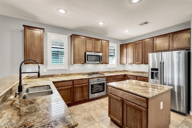 7806 Sundial Peak St, Las Vegas, NV 89166 - kitchen featuring stainless steel appliances, light stone counters, recessed lighting, light tile patterned flooring, and a center island