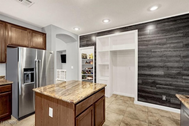 7806 Sundial Peak St, Las Vegas, NV 89166 - kitchen with stainless steel refrigerator with ice dispenser, arched walkways, light stone countertops, and recessed lighting