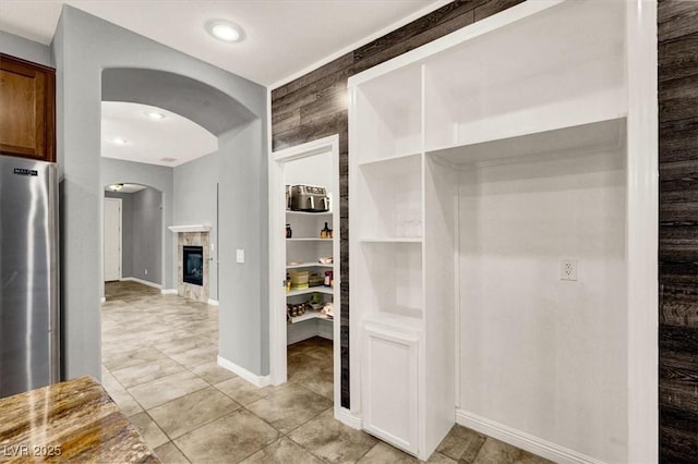 7806 Sundial Peak St, Las Vegas, NV 89166 - hall featuring arched walkways, baseboards, and light tile patterned flooring