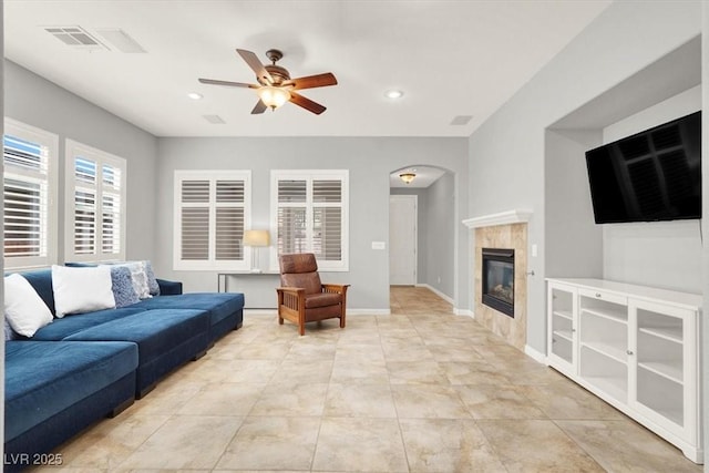 7806 Sundial Peak St, Las Vegas, NV 89166 - living area featuring ceiling fan, arched walkways, a tiled fireplace, recessed lighting, and baseboards