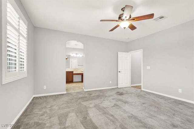 7806 Sundial Peak St, Las Vegas, NV 89166 - unfurnished bedroom with light carpet, arched walkways, baseboards, and ensuite bathroom