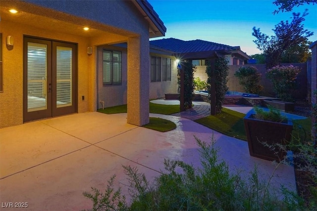 7806 Sundial Peak St, Las Vegas, NV 89166 - patio terrace at dusk featuring french doors, a patio, and a fenced backyard