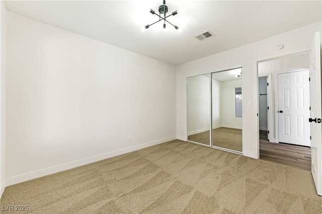 unfurnished bedroom with baseboards, carpet flooring, visible vents, and a closet