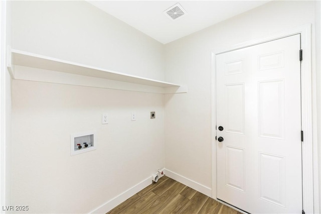 washroom with baseboards, visible vents, hookup for a washing machine, wood finished floors, and laundry area