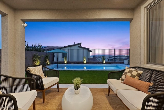 pool at dusk featuring outdoor lounge area, a fenced in pool, and fence