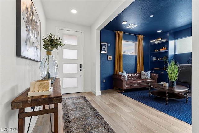 entryway with wood finished floors, baseboards, visible vents, and recessed lighting