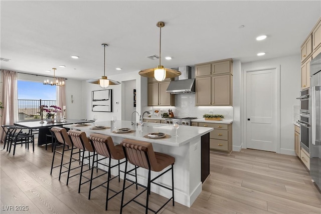kitchen featuring wall chimney range hood, recessed lighting, and light wood-type flooring