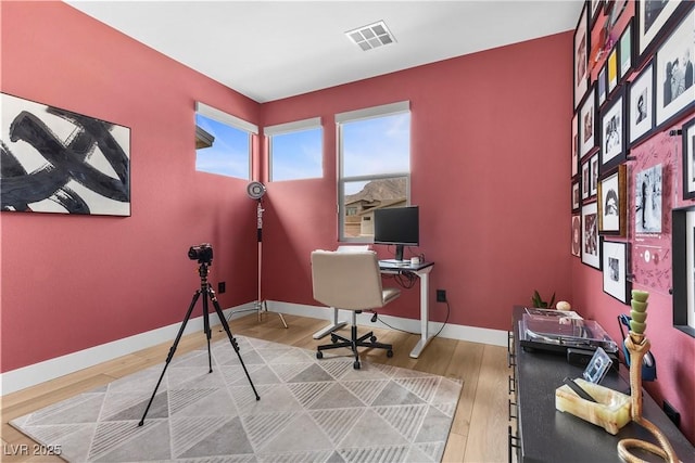 office area with wood finished floors, baseboards, and visible vents